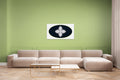 Beige sectional sofa in a living room with a green wall and geometric white, black and green artwork on wall.