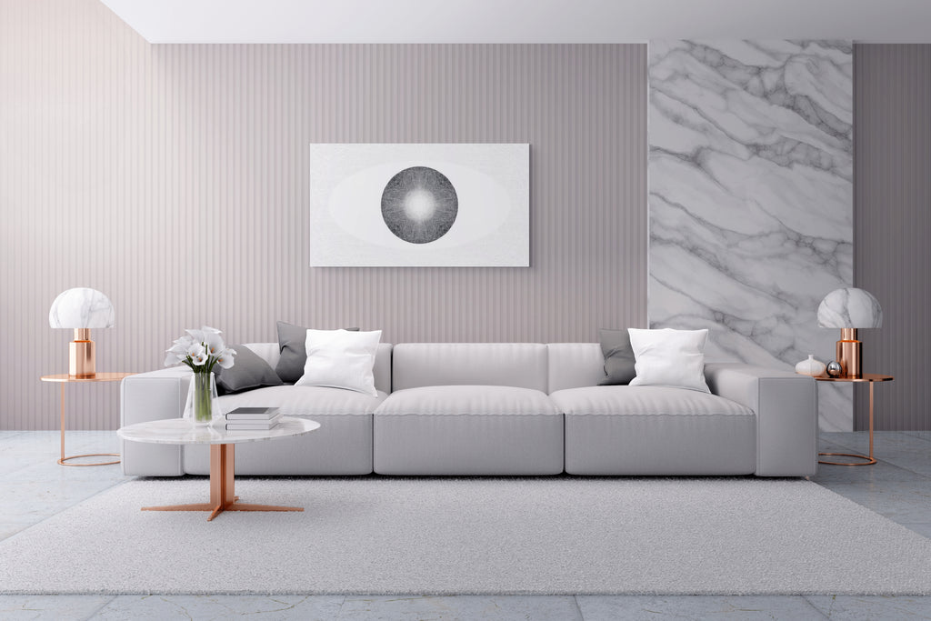Modern living room with a gray sofa, marble accent wall, minimal decor and a white, black and grey artwork on the wall.